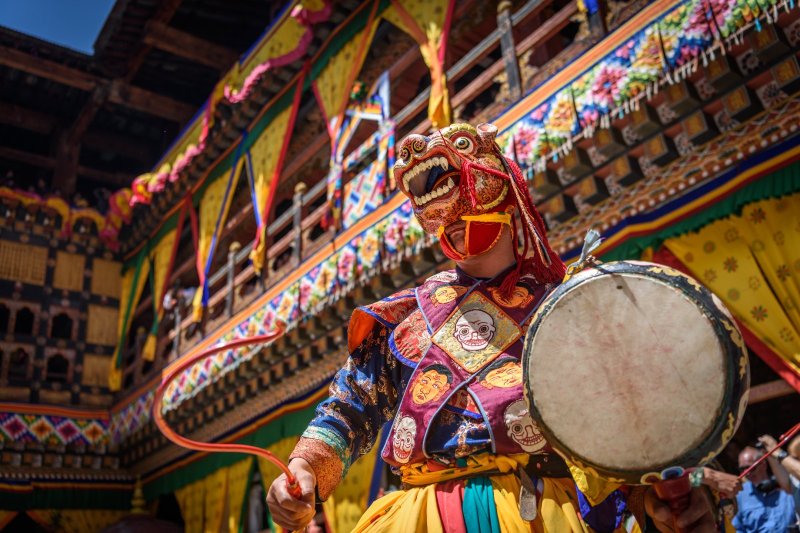 Bután: monje danzando en el festival Paro Tsechu con coloridas máscaras tradicionales