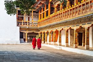 Bután: monjes budistas con túnicas rojas en el patio de Punakha Dzong