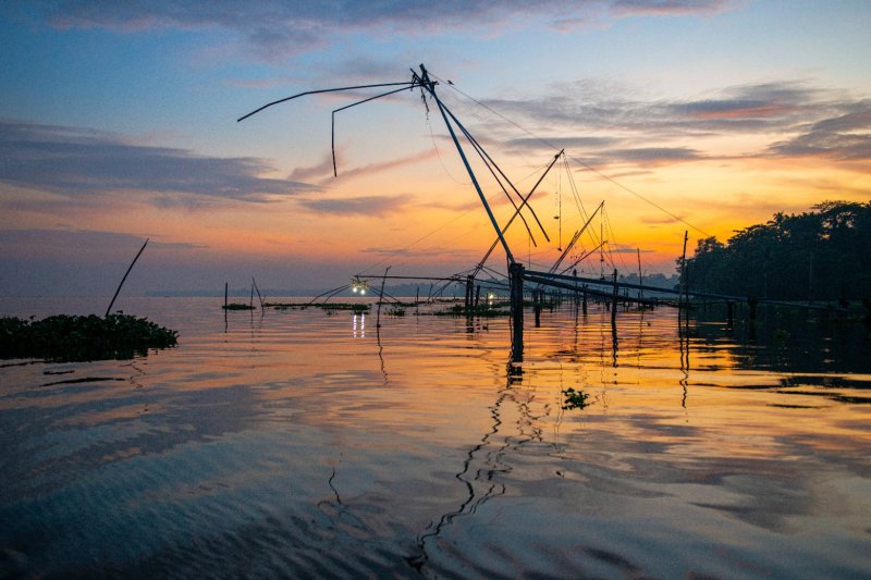 India: redes de pesca chinas al atardecer en el lago Vembanad, Kerala