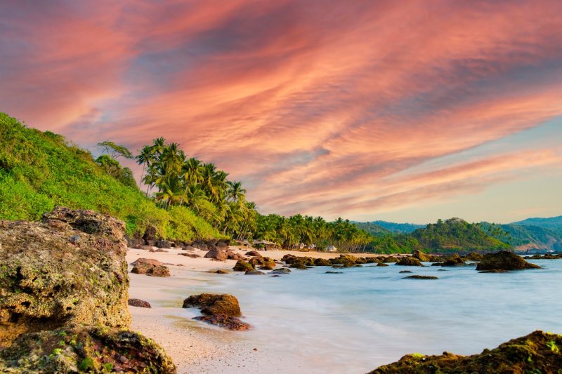 India: playa de Marari al atardecer entre palmeras, Kerala