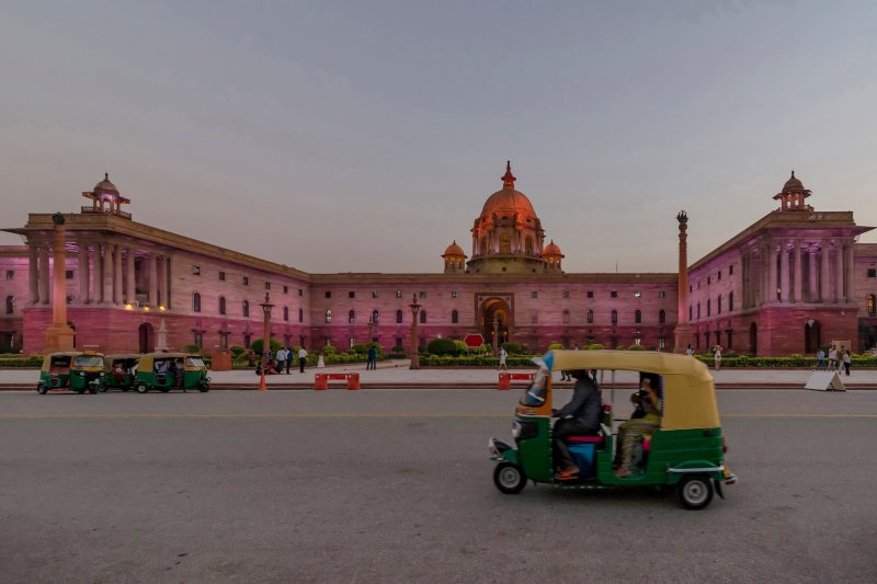 India: tuk tuk frente al South Block de Nueva Delhi al atardecer