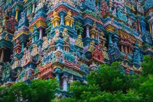 India: coloridos gopurams del templo Meenakshi Sundareswarar entre la vegetación