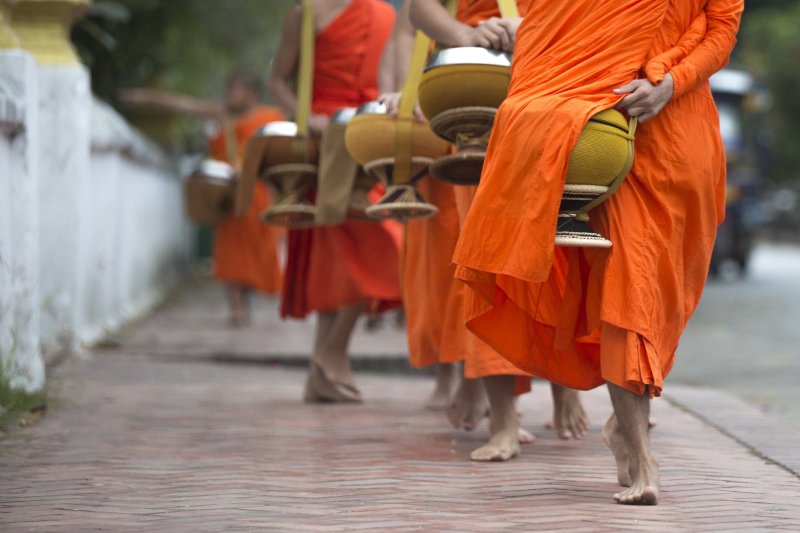 Laos: monjes budistas en la tradicional ceremonia de ofrendas matutinas de Luang Prabang