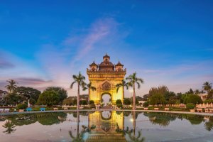 Laos: Patuxai iluminado al atardecer sobre el horizonte de Vientián