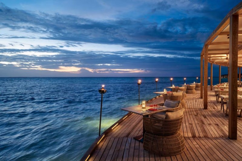 Maldivas: terraza del restaurante Sea, Fire, Salt al anochecer en Anantara Dhigu