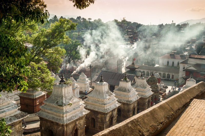 Nepal: humo sobre los ghats funerarios de Pashupatinath en Katmandú