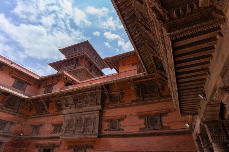 Nepal: patios de ladrillo y arquitectura de madera tallada en Hanuman Dhoka Durbar Square, Katmandú
