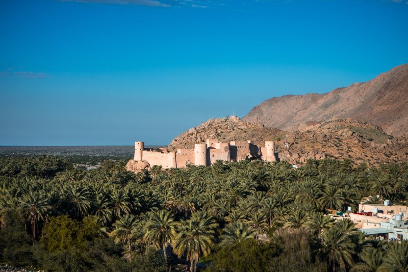 Omán: fuerte de Nakhal al atardecer rodeado de palmeras