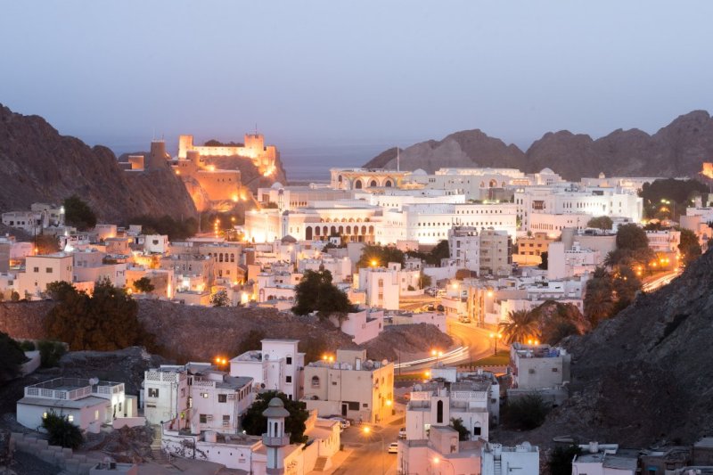 Omán: edificios históricos de Mascate al anochecer con vistas al fuerte Al Jalali