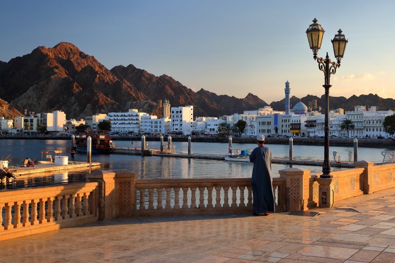 Omán: Corniche de Muttrah al atardecer con mezquita y montañas de Mascate