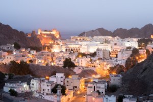 Omán: edificios históricos de Mascate al anochecer con vistas al fuerte Al Jalali