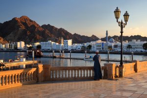 Omán: Corniche de Muttrah al atardecer con mezquita y montañas de Mascate