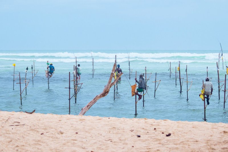 Sri Lanka: pescadores sobre zancos al atardecer en la playa de Weligama