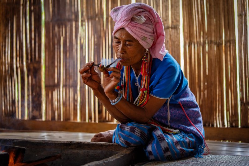 Tailandia: mujer de la etnia karen fumando una pipa tradicional en Mae Klang Luang, Chiang Mai