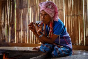 Tailandia: mujer de la etnia karen fumando una pipa tradicional en Mae Klang Luang, Chiang Mai