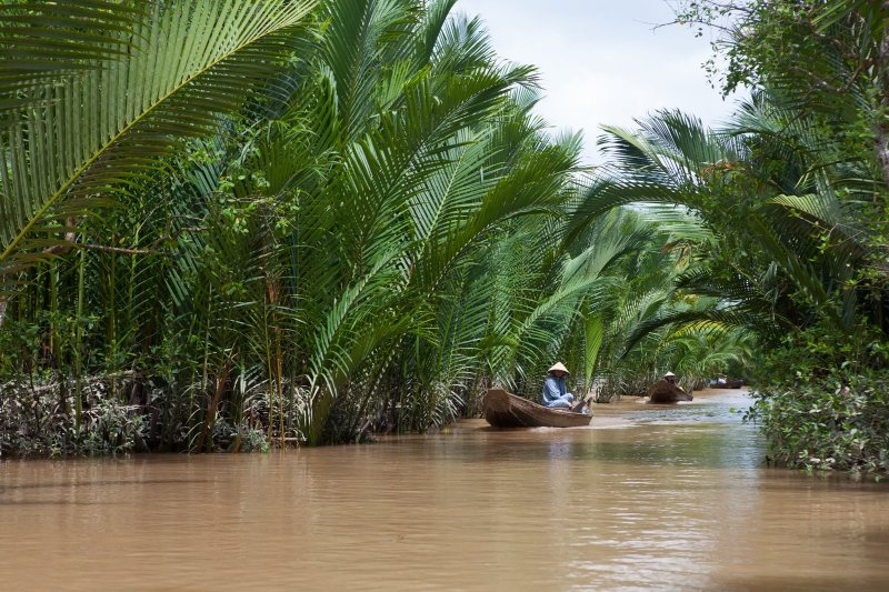 Vietnam: mujer local navegando en una barca tradicional por el río Mekong